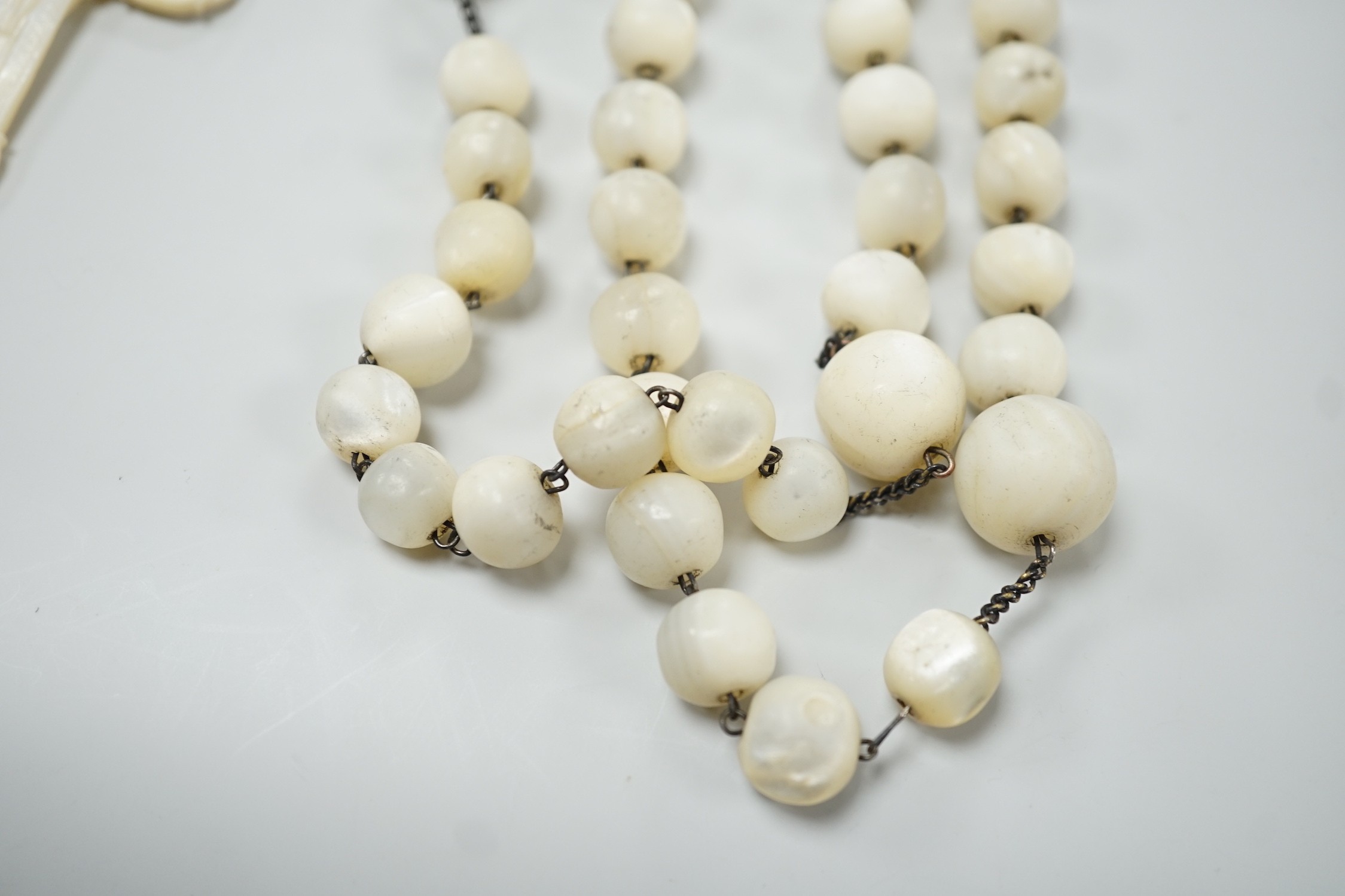 A long mother of pearl rosary, 158cm, with carved mother of pearl crucifix pendant, 8cm.